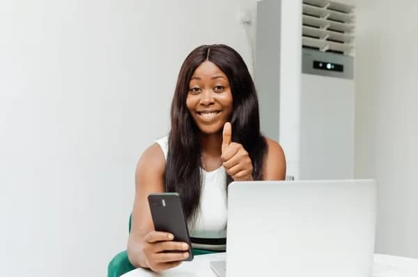 woman smiling while using her phone